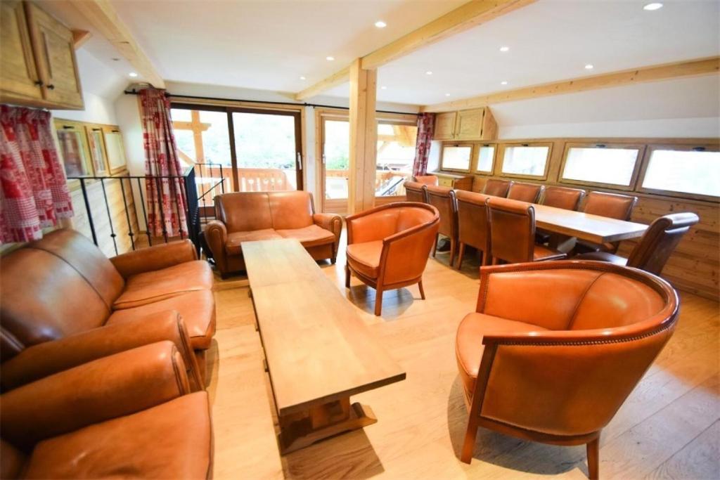 comedor con sillas de cuero y mesa en Chalet L'alpicois - Chalet L'ALPICOIS 10 pers - PLAGNE CENTRE -wifi - MAE-3584, en Aime La Plagne