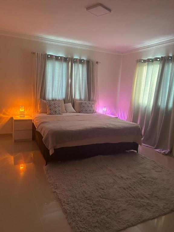 a bedroom with a large bed with pink lights at Vista al Caribe in Los Mameyes