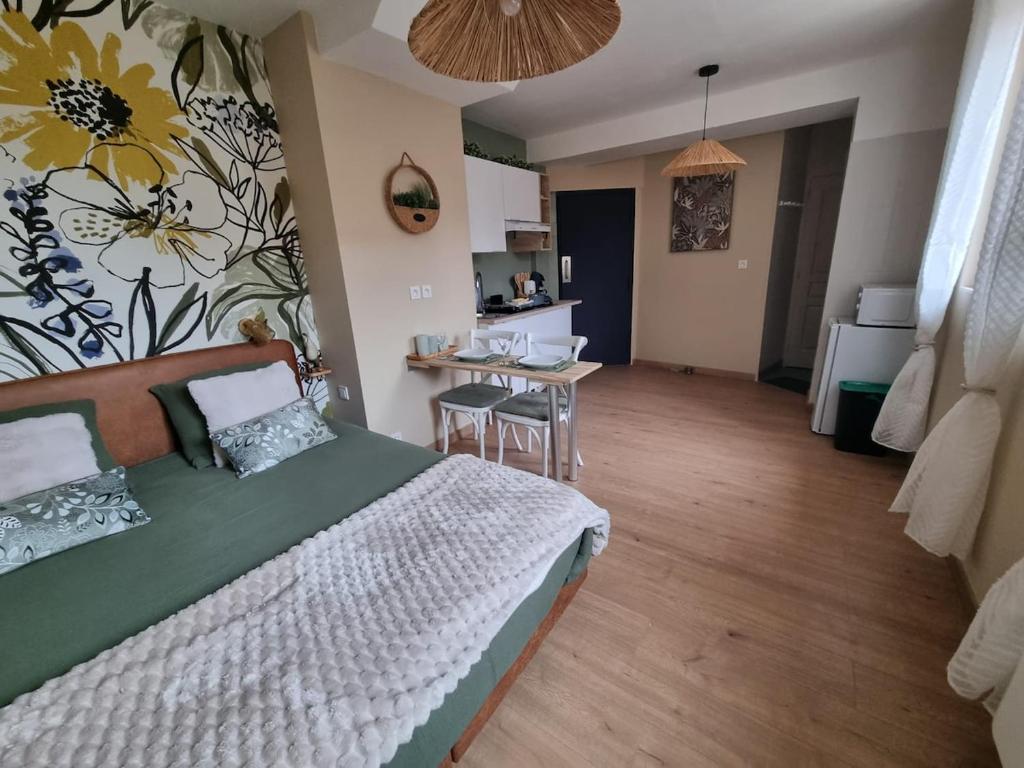 a bedroom with a bed and a table with chairs at Le Petit Marais in Saint-Martin-lez-Tatinghem