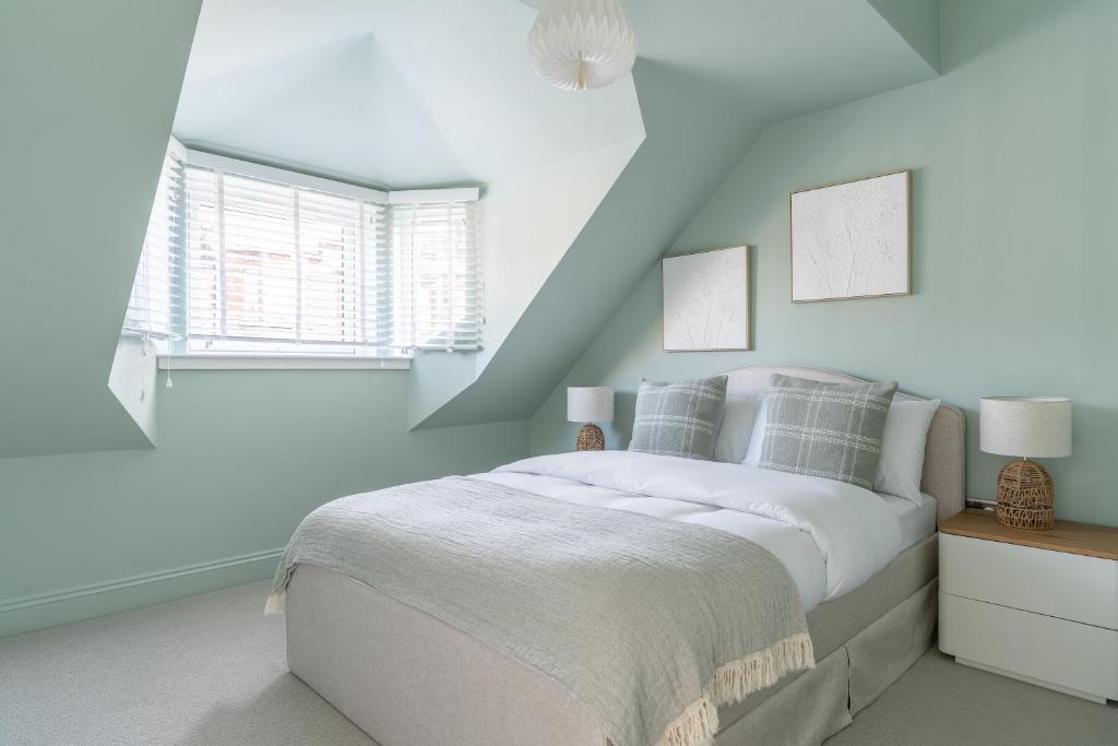 a white bedroom with a bed and a window at Prime Stay Apartments in Paisley