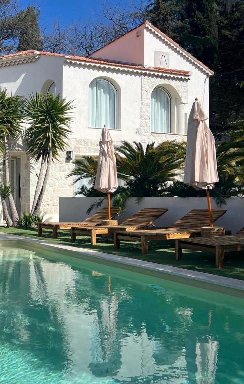 une maison avec deux parasols et une piscine dans l'établissement Luxury Riviera Villa* short walk to beach & center, à Cagnes-sur-Mer