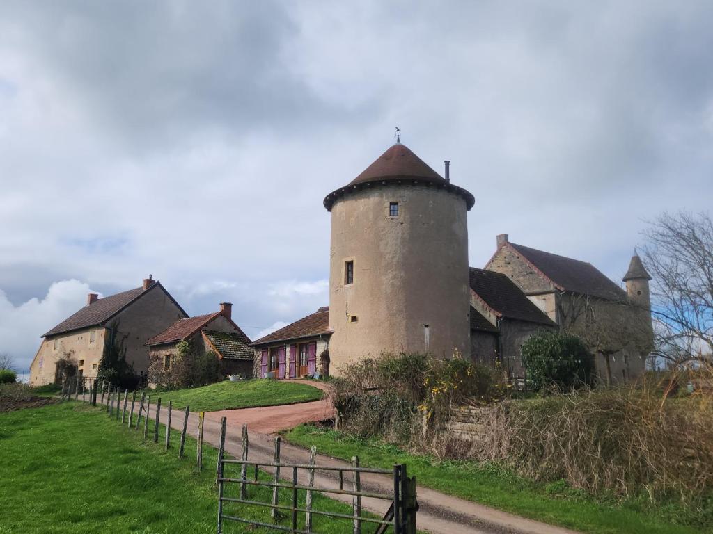 un bâtiment avec une tour sur le côté d'une route dans l'établissement la tour de garde, à Saint-Aubin-en-Charollais