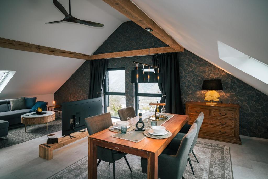 un soggiorno con tavolo e sedie in legno di Idyllic Loft Kumani Ago - Villa Rizas Hills a Traben-Trarbach