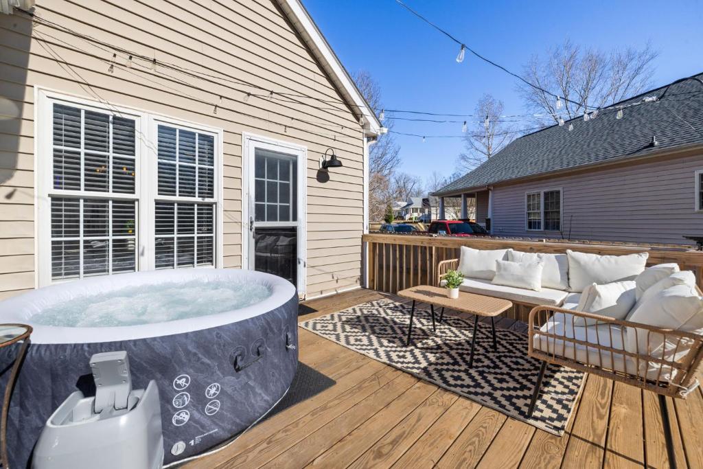 a hot tub on a deck next to a house at 3BD Retreat - Hot Tub & BBQ - Near NCSU & Downtown in Raleigh