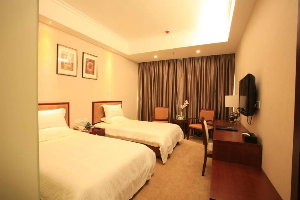 Habitación de hotel con 2 camas y escritorio en GreenTree Inn Beijing Xicheng District Caishikou Express Hotel, en Beijing