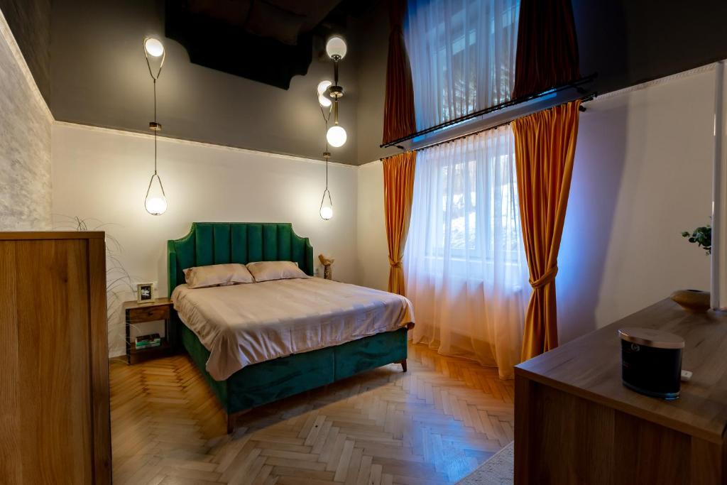 a bedroom with a green bed and a window at Apartament ACs Studio in Sighişoara