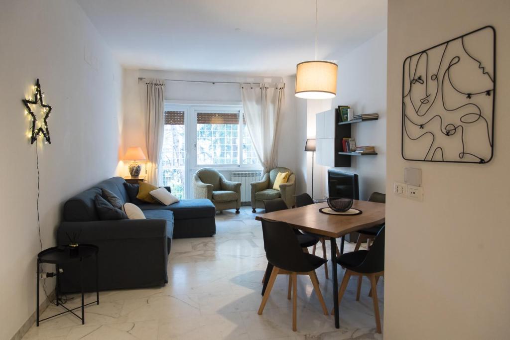 un soggiorno con un divano blu e un tavolo di Casa Eva - Roma a Roma