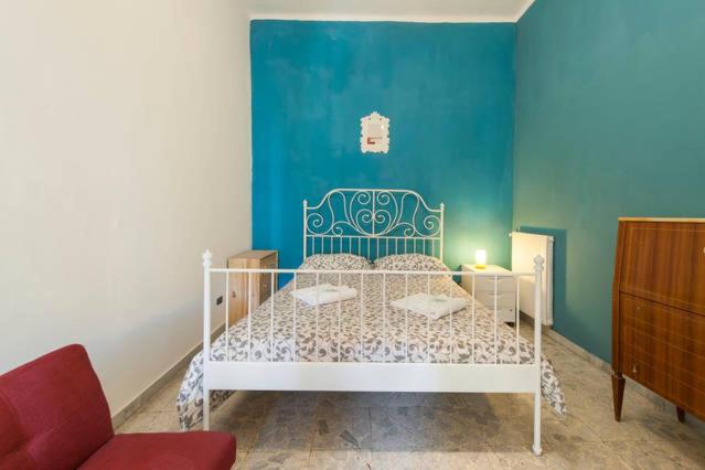 een slaapkamer met een wit bed en een blauwe muur bij Sarah's B&B in Rome