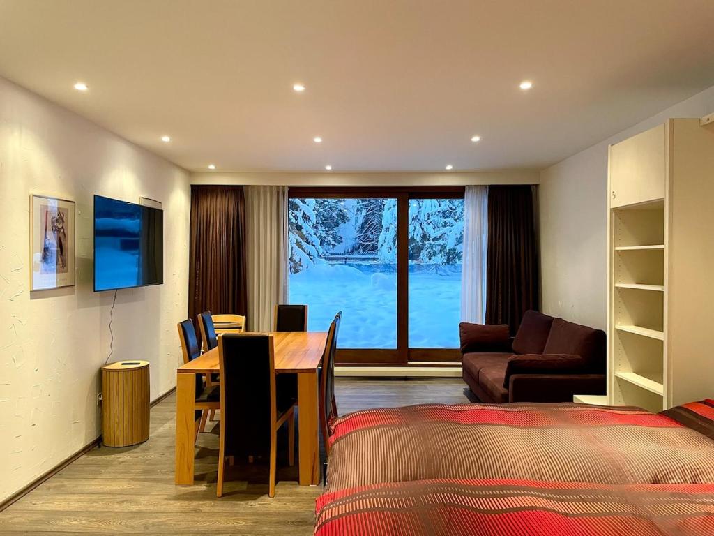 a room with a dining table and a living room at Apartment with Pool, Sauna & Gym in Laax