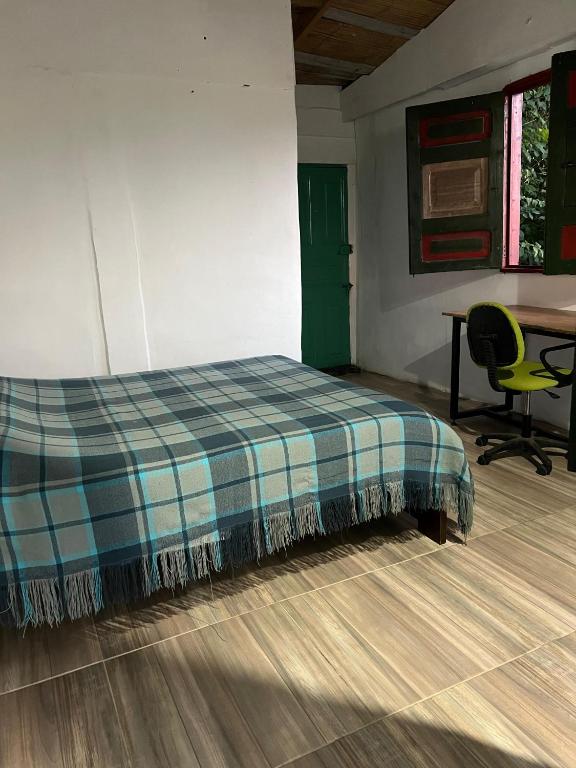 a bed in a room with a table and a chair at Atardecer De Salento in Salento