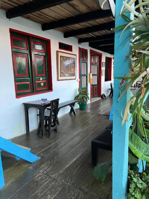 a room with a table and chairs and red doors at Atardecer De Salento in Salento