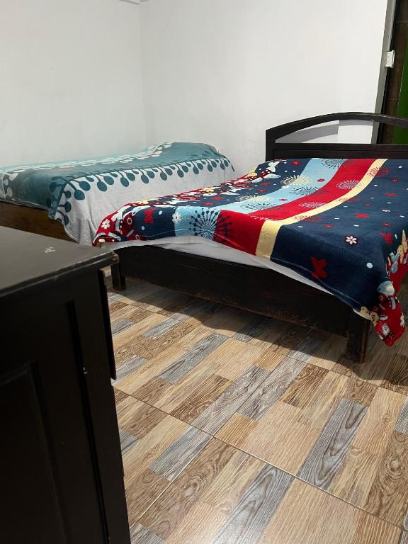 a bedroom with two beds and a wooden floor at Atardecer De Salento in Salento