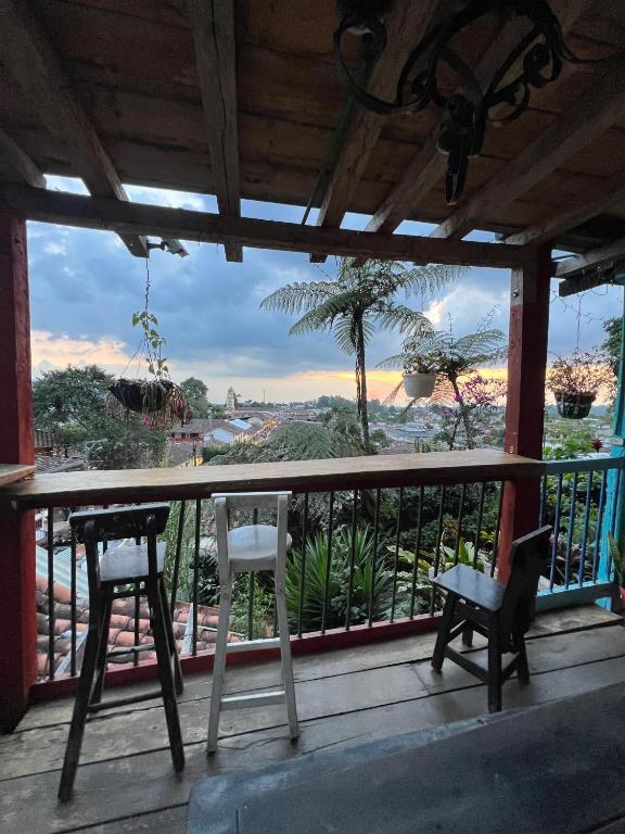 a balcony with two chairs and a view of the ocean at Atardecer De Salento in Salento