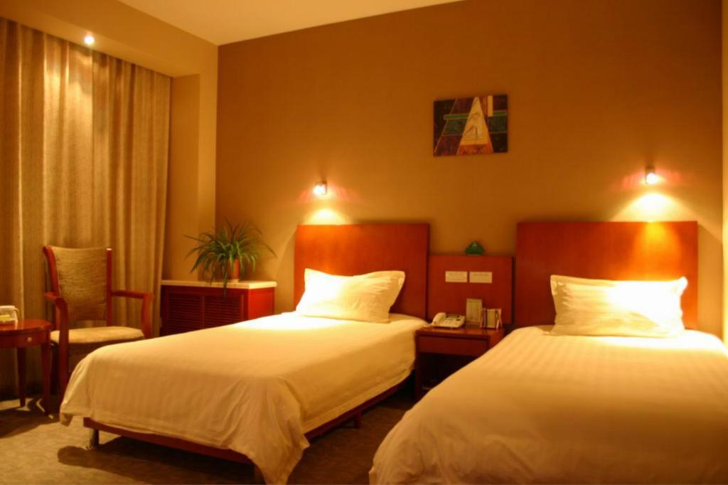 a hotel room with two beds and a chair at GreenTree Inn Beijing Changping Tiantongyuan East Taipingzhuang Road Express Hotel in Changping