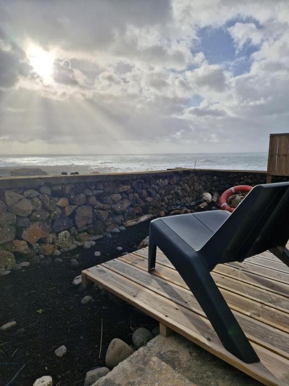 a bench sitting on top of a wooden deck overlooking the ocean at Casa Bidarta in Faja Grande