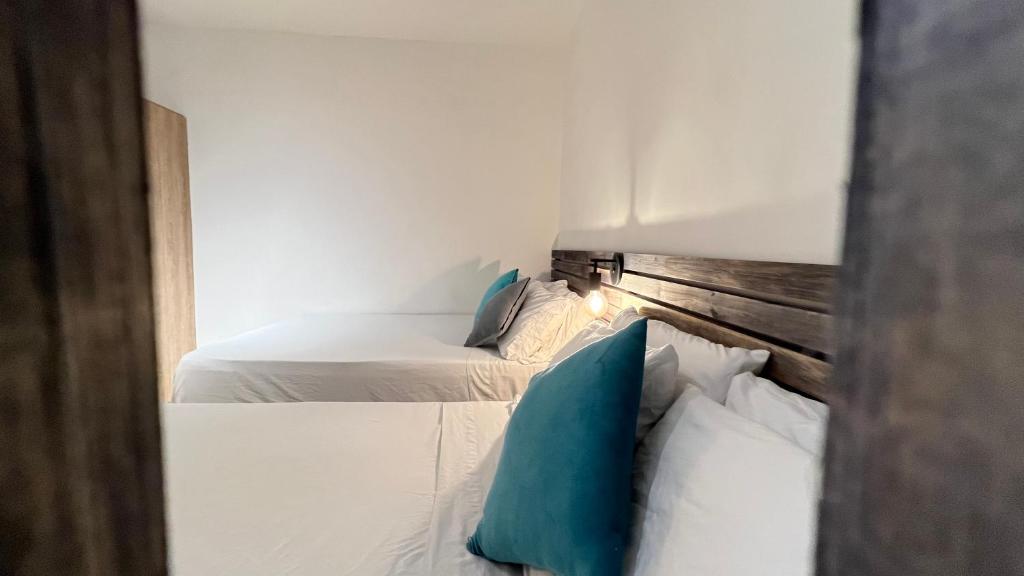 two white beds in a room with blue pillows at HOTEL 9.5 SAN FERNANDO in Cali