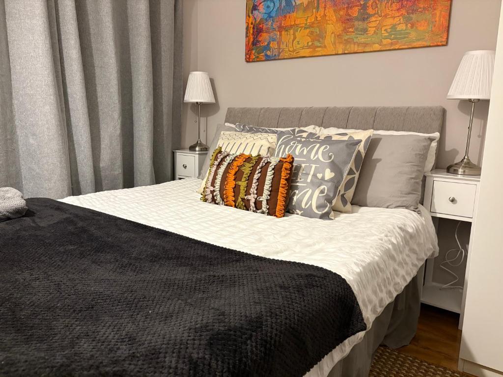 ein Schlafzimmer mit einem Bett mit Kissen darauf in der Unterkunft Beautiful Rooms near Hampton Court in Molesey