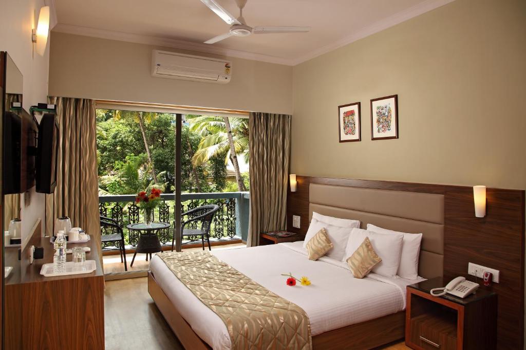 a hotel room with a bed and a balcony at The Hawaii Comforts in Panaji