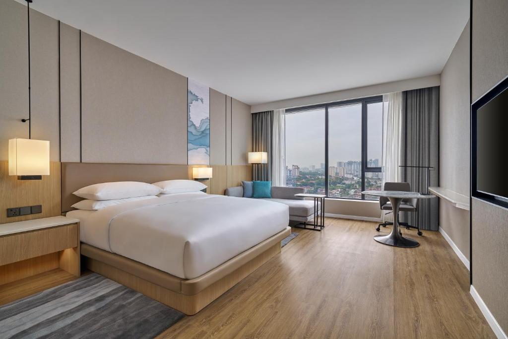 A modern king room with a large window, television and compact desk.