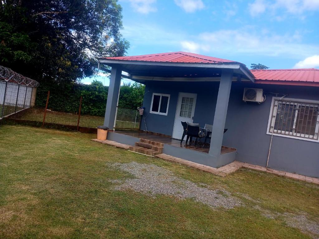 una pequeña casa azul con techo rojo en La casita de Issa via Boquete, en David
