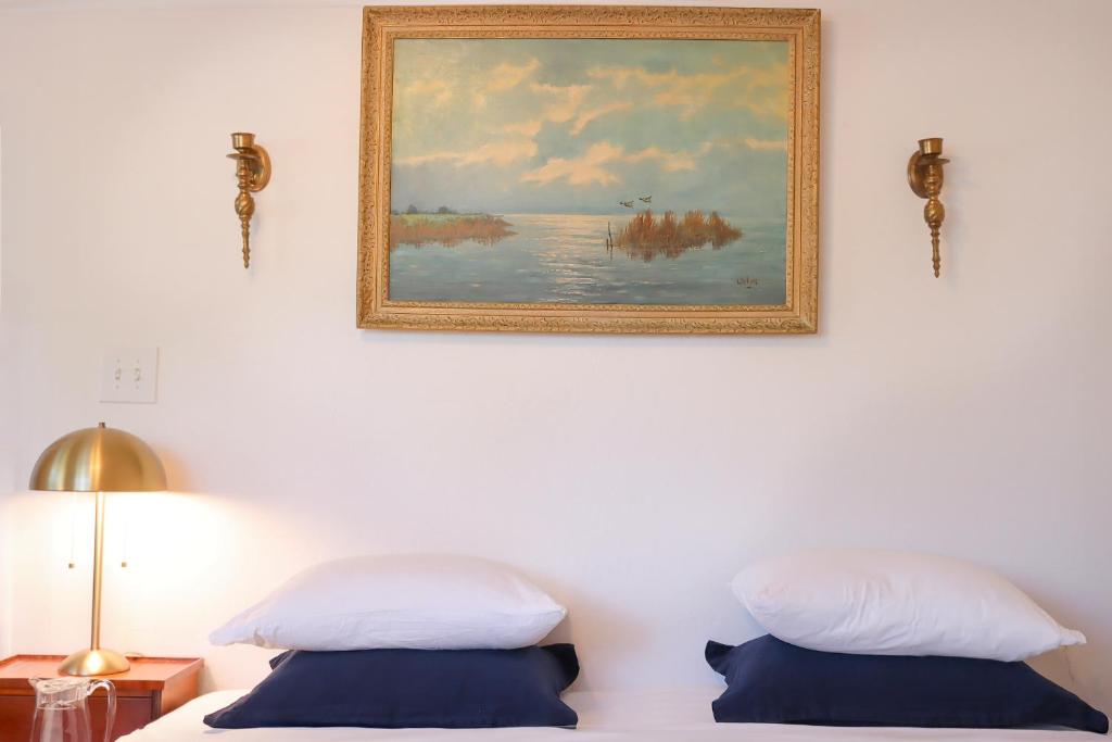 a bedroom with two beds and a painting on the wall at 1 BR Orchard Cottage - Gateway to Two National Parks! in Visalia