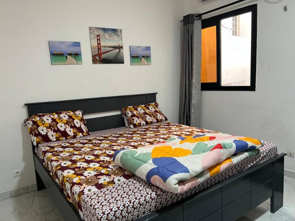 a bed with a quilt on it in a room at West Side Résidence in Dakar