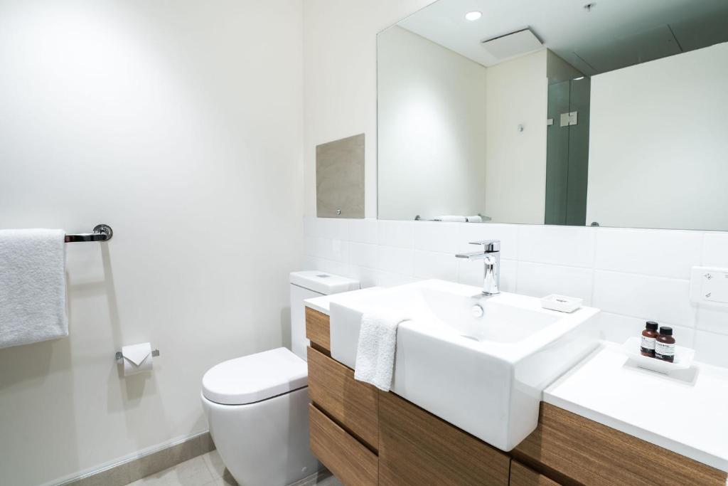 a bathroom with a sink and a toilet and a mirror at Mary MacKillop Place in Sydney