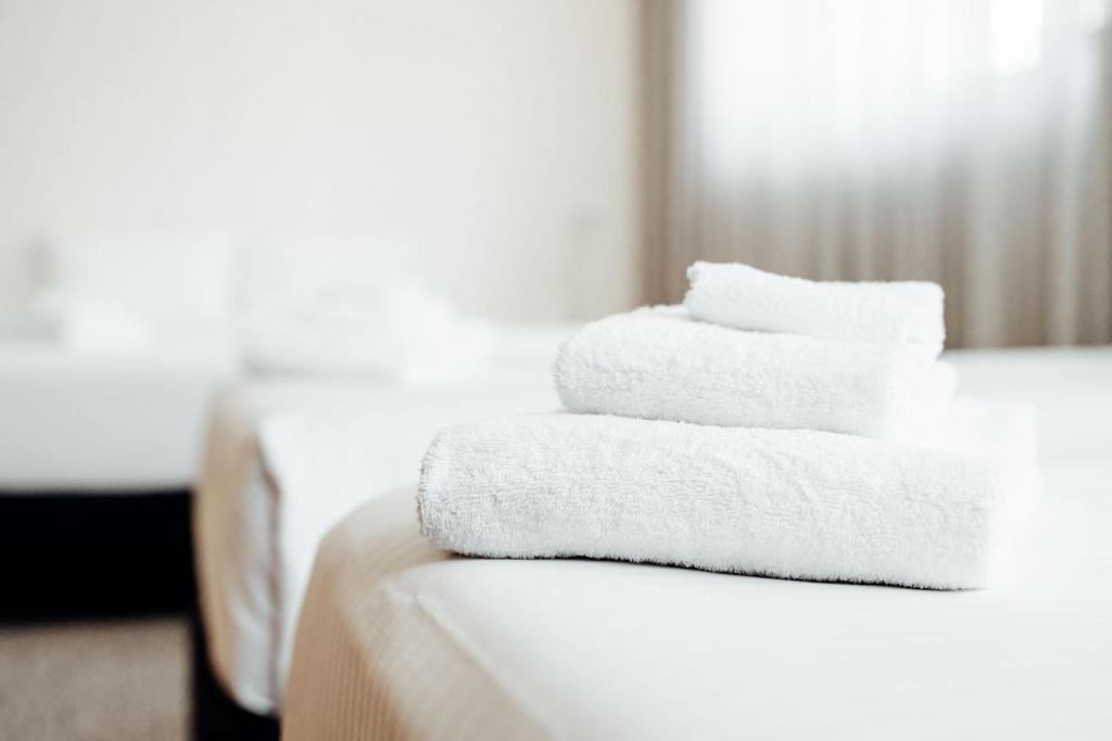three towels stacked on a table in a hotel room at Mary MacKillop Place in Sydney