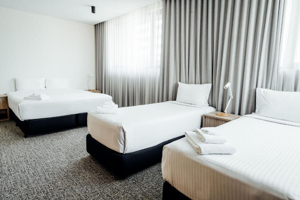 a hotel room with two beds with white sheets at Mary MacKillop Place in Sydney