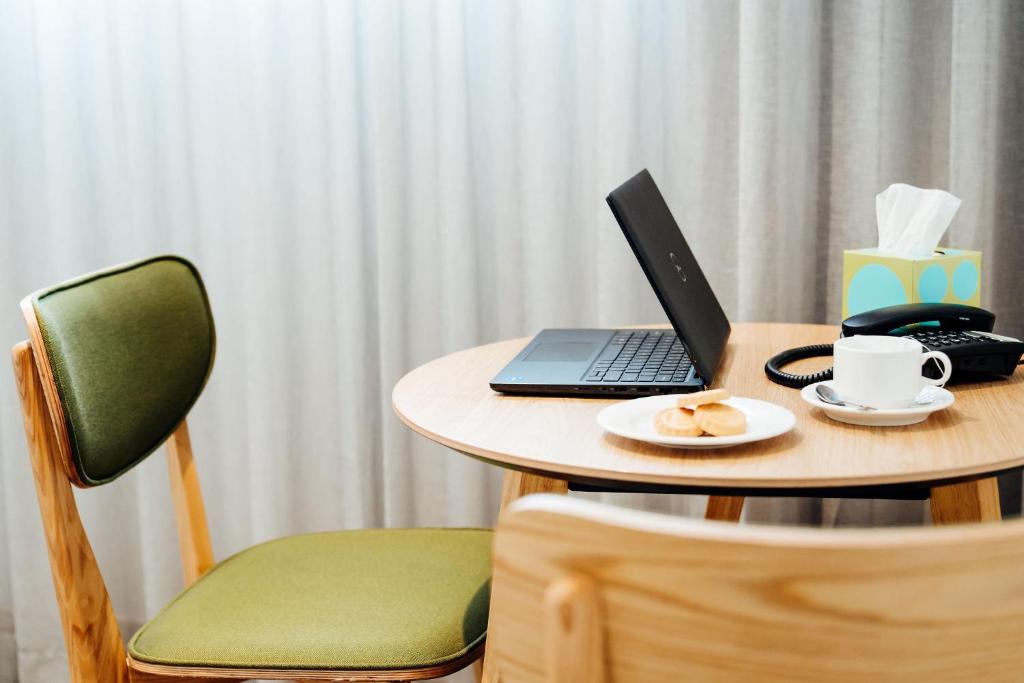 a table with a laptop and a cup of coffee on it at Mary MacKillop Place in Sydney