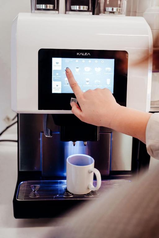 a person is pointing at a coffee machine at Mary MacKillop Place in Sydney