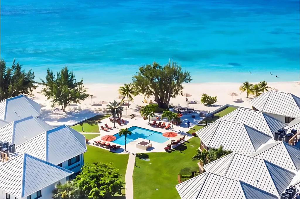 an aerial view of a resort with a pool and the ocean at 3Bed Oceanview with Pool on Seven Mile Beach in Seven Mile Beach