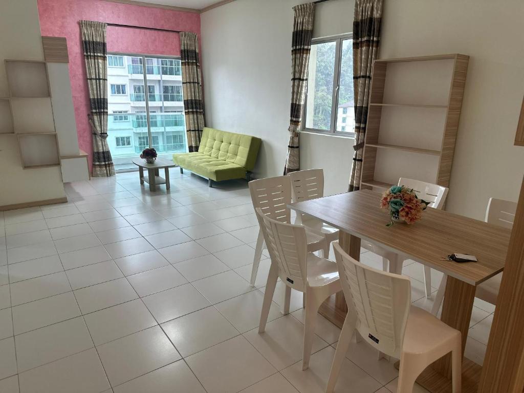 a dining room with a table and chairs and a couch at Family Stay at Quintet A3A-3A-6 in Tanah Rata
