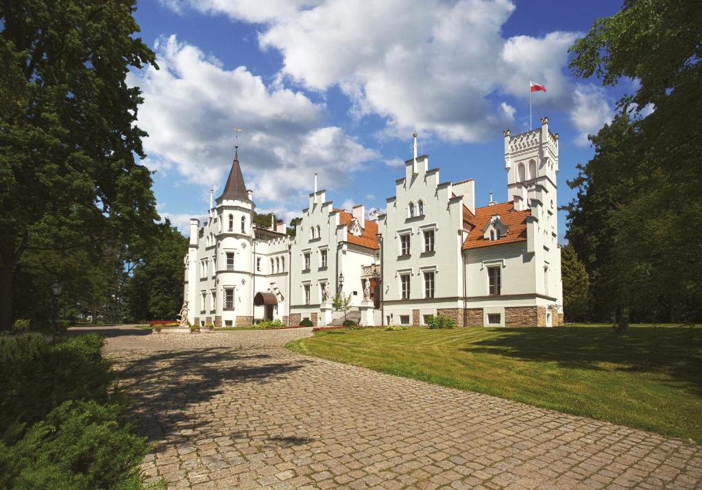 un gran edificio blanco con una torre encima en Pałac Sulisław, en Sulisław