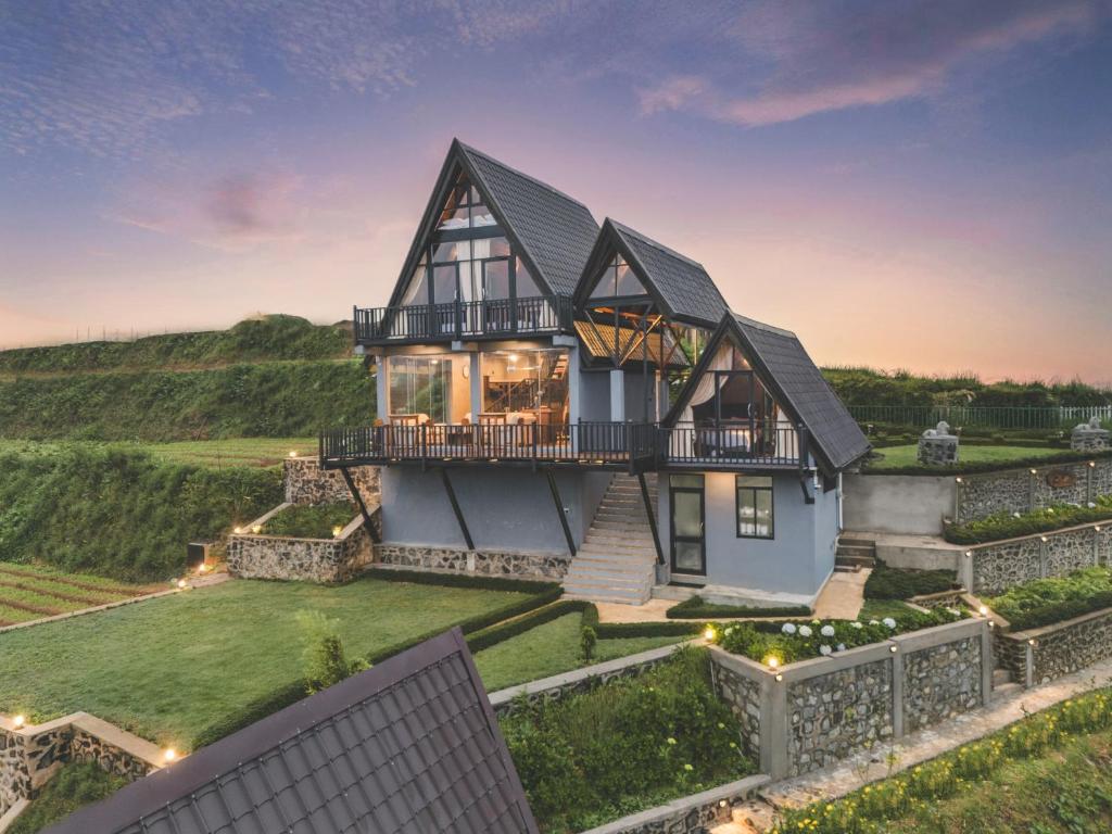 a house with a black roof at Bellevue Chalets by Pushella in Nuwara Eliya