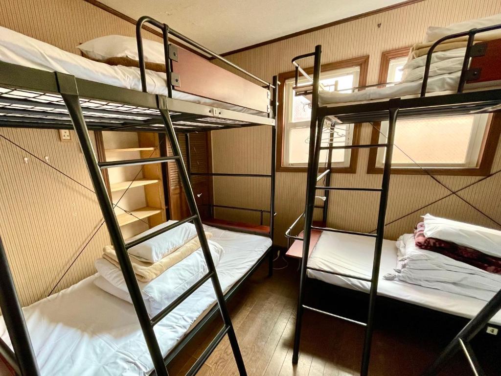 Tempat tidur dalam kamar di IZA Kamakura Guest House and Bar