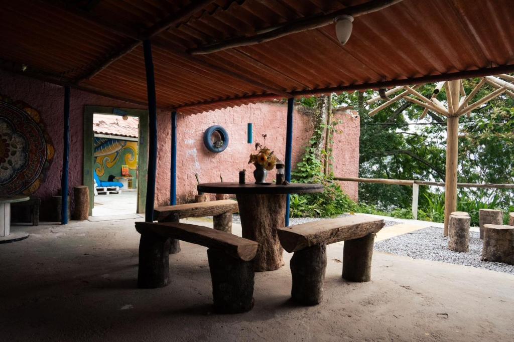 a table and two benches in a pavilion at Suites com vista para o Mar in Angra dos Reis