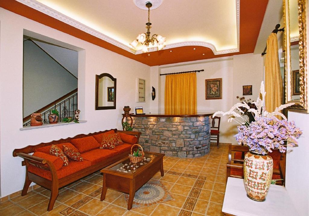 a living room with a couch and a stone fireplace at Artemis Traditional Hotel in Myrina