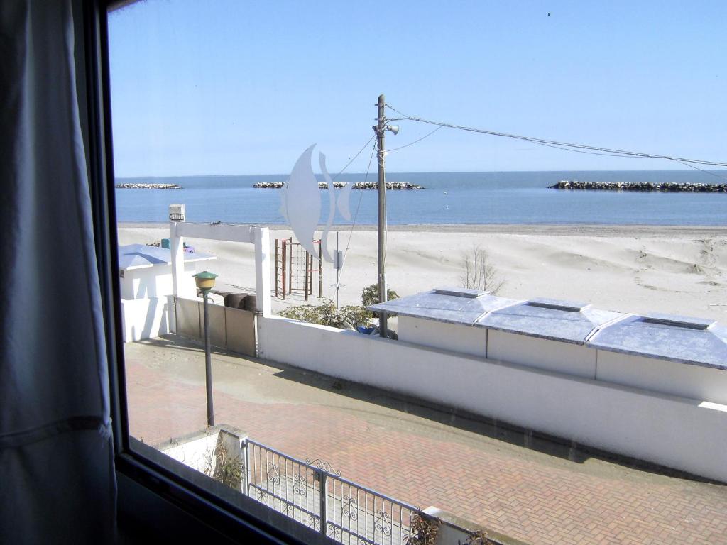 リド・デッレ・ナツィオーニにあるHoliday Home Cenamの窓付きの客室からビーチの景色を望めます。