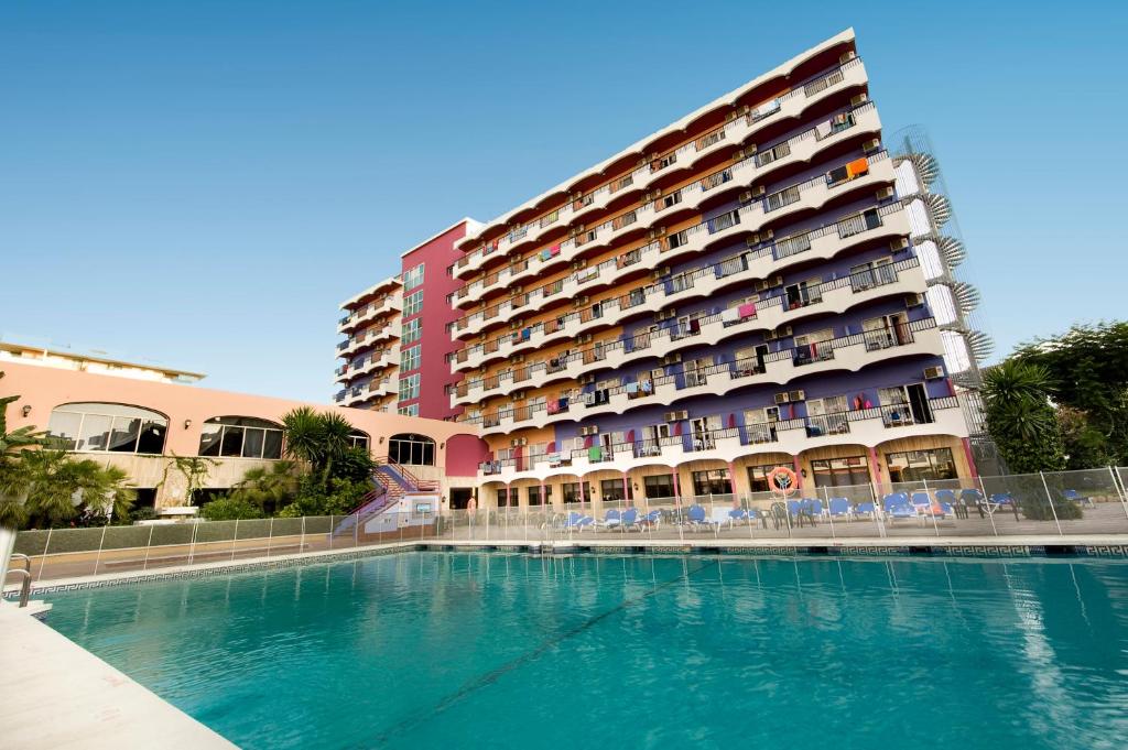 un hôtel avec une piscine en face d'un bâtiment dans l'établissement Hotel Monarque Fuengirola Park, à Fuengirola