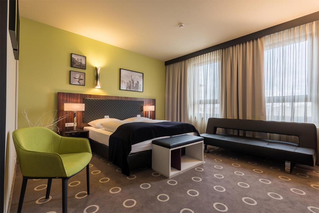 ein Hotelzimmer mit einem Bett und einem Stuhl in der Unterkunft The Frankfurt in Frankfurt am Main