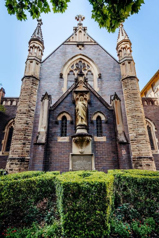 a church with a statue on the front of it at Mary MacKillop Place in Sydney