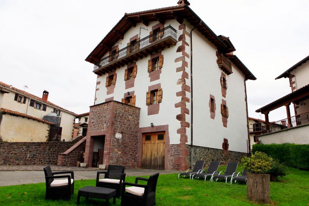 - un bâtiment avec des chaises devant dans l'établissement Casa Aldekotxeberria, à Ziga