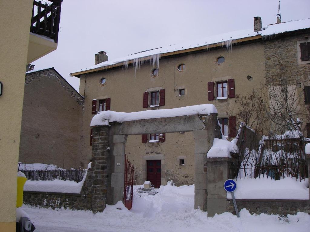 un viejo edificio con nieve delante en La Maison Bleue, en La Cabanasse