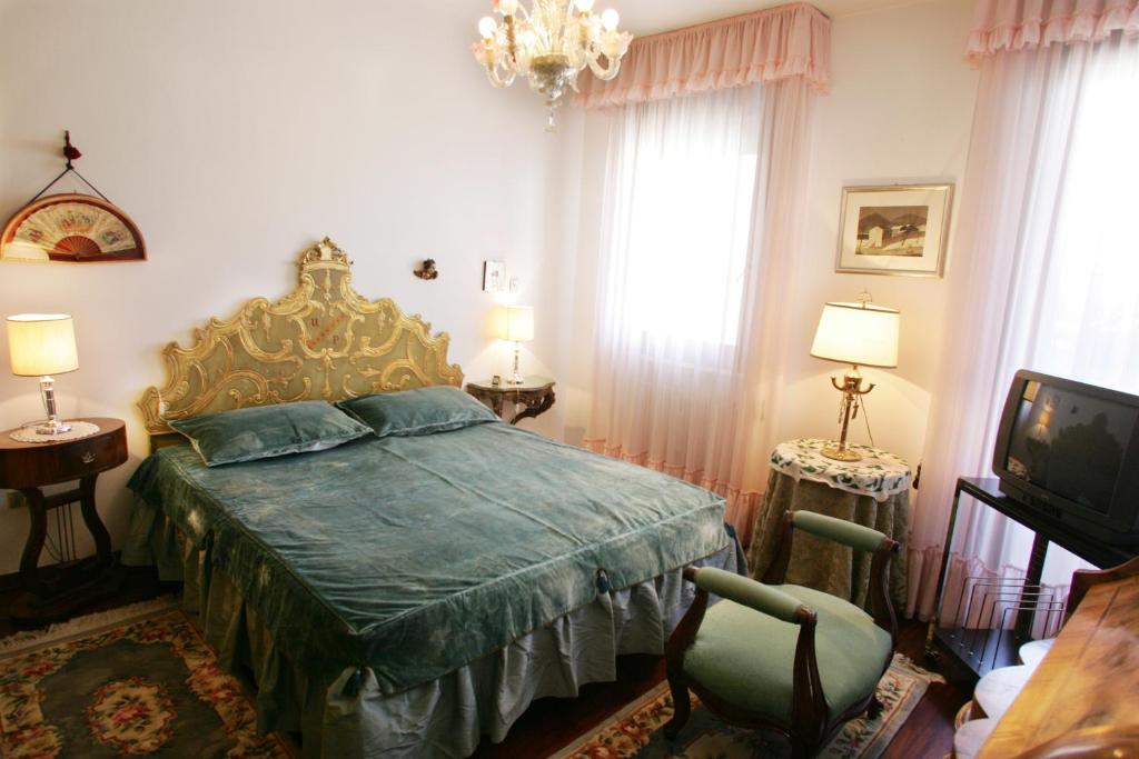 una camera da letto con un letto con un piumone verde e una TV di B&B Il Glicine Fiorito a Lido di Venezia