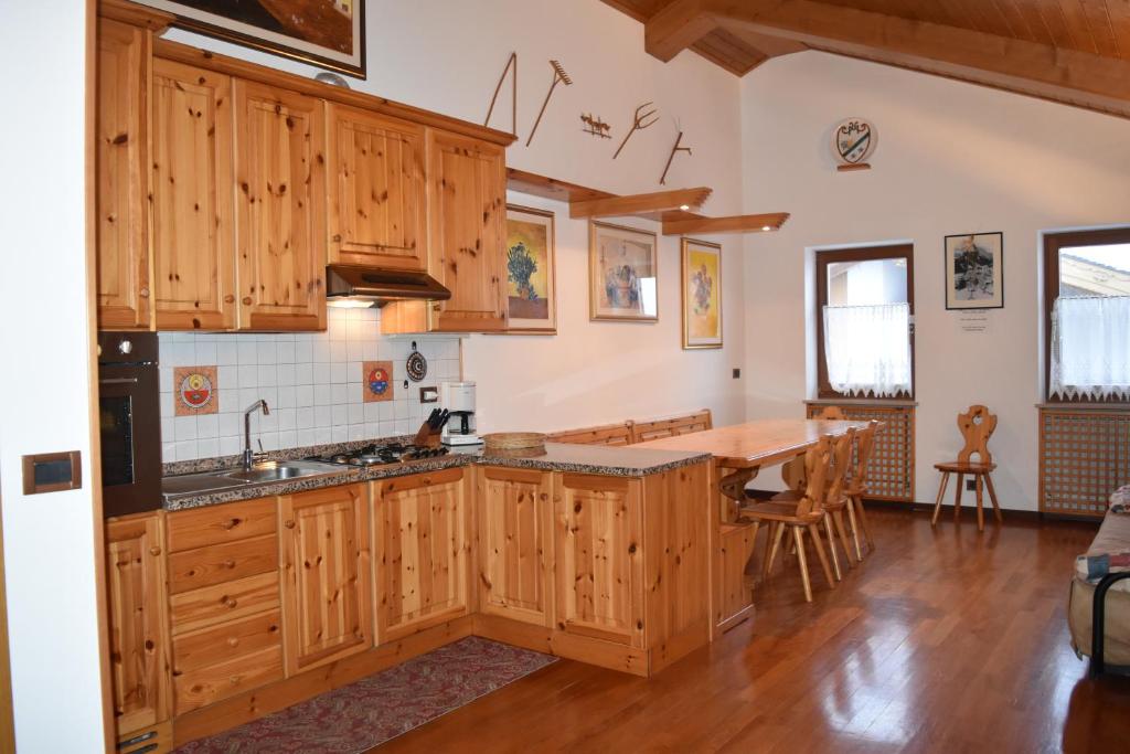 una cucina con armadi in legno e tavolo in legno di Appartamento Sellaronda ad Arabba