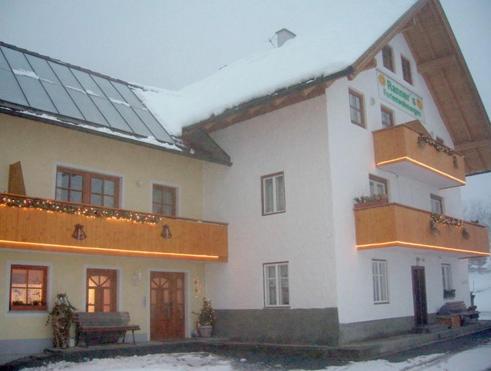 a large white building with a balcony in the snow at Ranner's Ferienwohnung in Hermagor