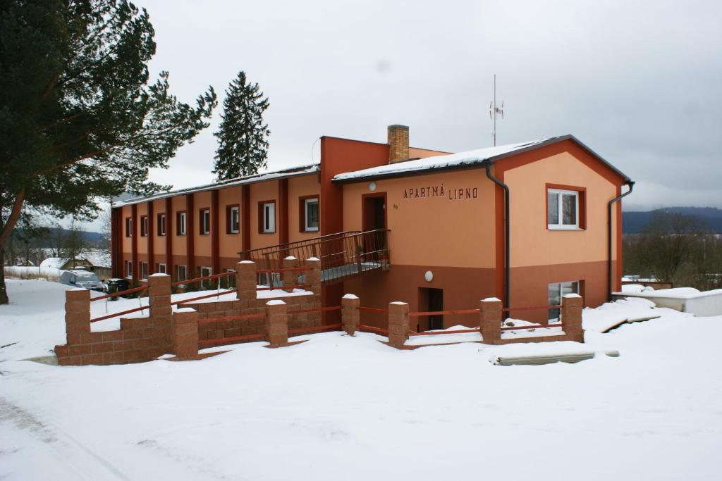 um edifício com neve em frente em Apartmá Lipno em Horní Planá