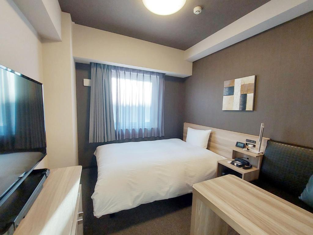 Postel nebo postele na pokoji v ubytování Hotel Route Inn Kusatsu Ritto -Ritto Inter Kokudo 1 gou-