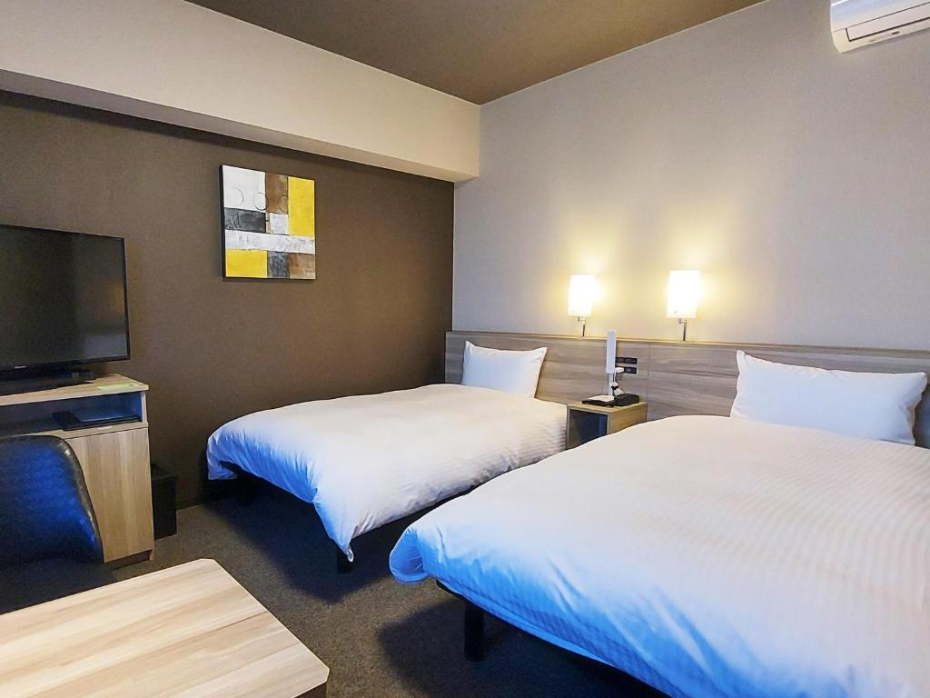 Postel nebo postele na pokoji v ubytování Hotel Route Inn Kusatsu Ritto -Ritto Inter Kokudo 1 gou-